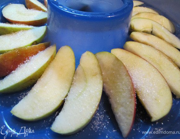 Яблоко разрезать на дольки, выложить в форму веером, притрусить сахаром