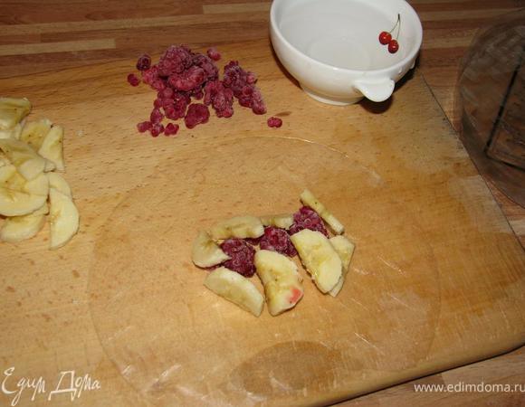 Смочить водой рисовую бумагу. Выложить малину и банан на середину листа. Завернуть блинчик.