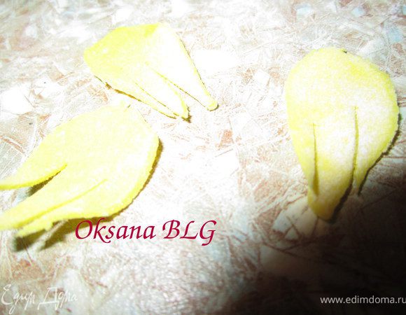 Из желтой мастики вырезать маленькие листики, на них сделать 2-3 разреза.