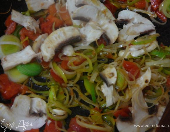 Добавить очищенные и нарезанные на кубики помидоры,тонко резанные и очищенные шампиньоны.Все перемешать,огонь уменьшить до минимума,накрыть крышкой и оставить тушиться минут на 10,так чтоб грибы и помидоры дали сок.