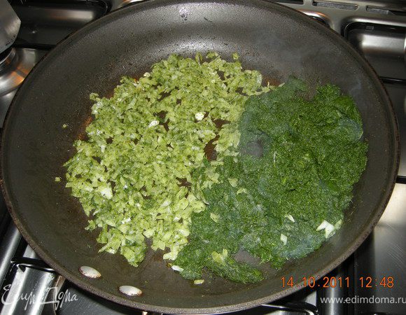 Лук нашинковать и обжарить на оливковом масле. К нему добавить замороженный шпинат , закрыть крышкой и тушить до готовности шпината. В конце добавить выдавленные дольки чеснока, посолить, поперчить и дать остыть.