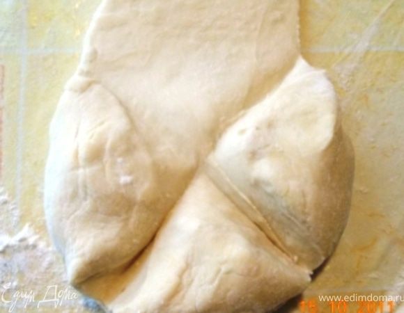 кладём тесто на посыпанный мукой стол, надрезаем крестом и раскатываем каждую часть, середина должна быть толще, чем края