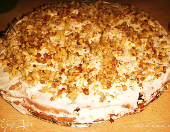 Выложить второй, сверху добавить 1/4 крема, посыпать сверху половиной количества орехов.


