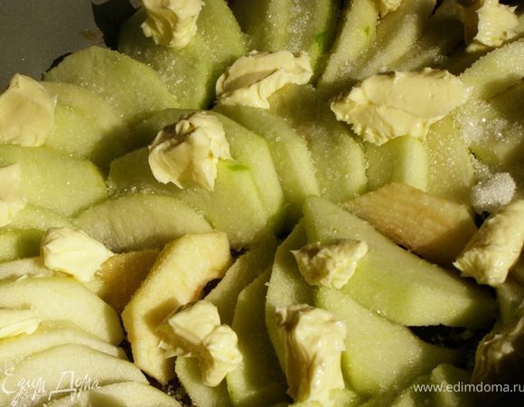 Посыпаем яблоки оставшимся сахаром, кладем по всей поверхности маленькие кусочки масла.