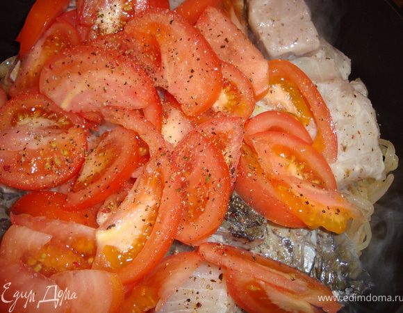 Сверху положить куски рыбы и помидоры, посолить и поперчить учитывая, что рыба уже посолена.