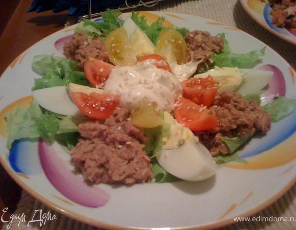Салат с тунцом. На тарелку рвем листья любого салата, кладем сверху порезанные на четвертинки яйцо, помидоры черри, тунец, в центр заправку: сметана, майонез, горчица дижонская. Посыпать кунжутом.