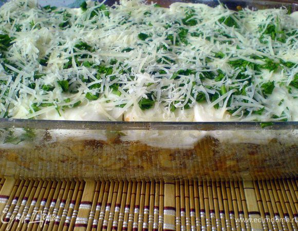 Форму смазываем маслом (1 ст.л.) и присыпаем сухарями. Выкладываем пасту с соусом. 
Нарезаем пластиками моцареллу, выкладываем поверх пасты. Посыпаем порубленной зеленью и оставшимся сыром (1/3).
