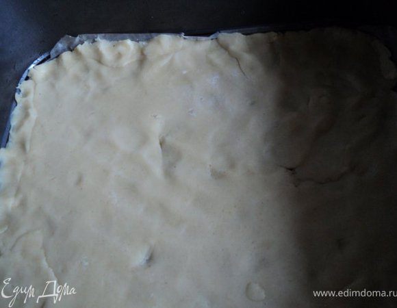 Дно формы для выпечки застелить бумагой для выпечки, смазать растительным маслом.
Одну часть теста раскатать по размеру формы ( у меня 30х30см ), выложить на дно. 
