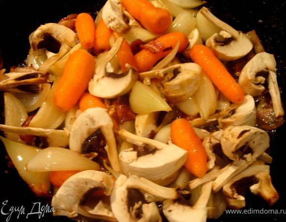Тем временем нарезать бекон и обжарить его на сухой сковороде.Затем к бекону добавить нарезанные лук и чеснок,следом кусочки моркови и в последнюю очередь грибы.Сдобрить сливочным маслом.Мелкие коренья и грибы лучше обжаривать целыми:так они эффектней смотрятся.:)))Прикрыть крышкой и немного потомить.