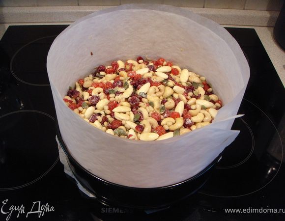 Вынуть пирог из духовки примерно за 15 мин до готовности и осторожно распределить по нему оставшиеся три ложки смеси, а поверх нее - ягоды и орехи. Отправить обратно в духовку на 15 минут. Готовность пирога проверять зубочисткой