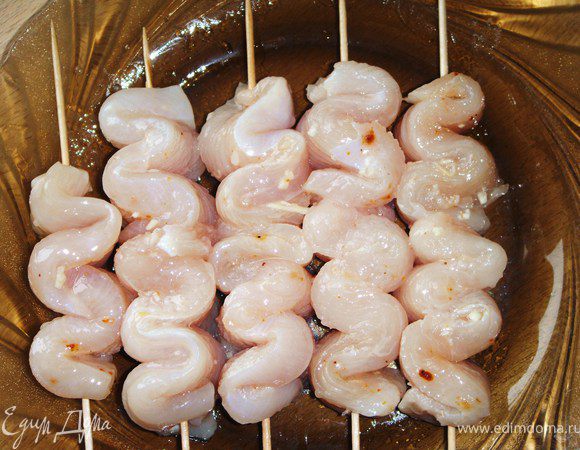 Нанизать полоски курицы «волнами» на деревянные шпажки, посыпать кунжутными семенами.
