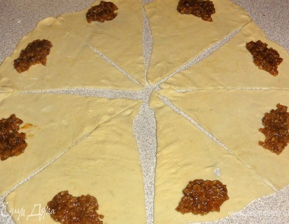 Тесто разделите на 4 части. Каждую часть тонко раскатайте  в форме круга.
Разрежьте пласт так, что бы у вас получилось 8 треугольников.  На широкую сторону положить ореховую смесь и завернуть в форме рогалика. 
