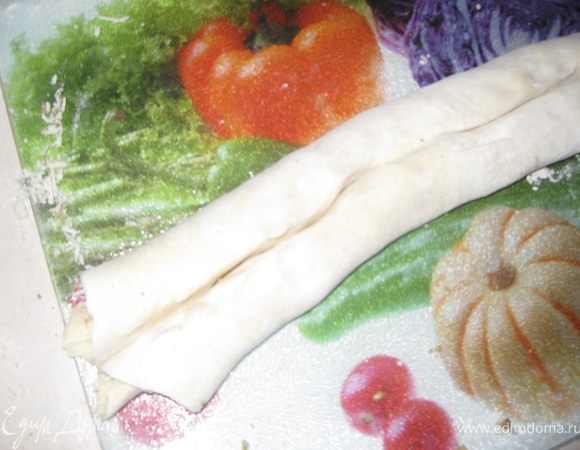 Одновременно с одного и другого конца начинаем сворачивать тесто рулетом к середине. Должно получится как на фото.