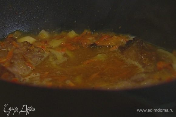 Разогреть куриный бульон и вылить в кастрюлю, так чтобы мясо было полностью покрыто. Накрыть крышкой и томить около часа на умеренном огне.