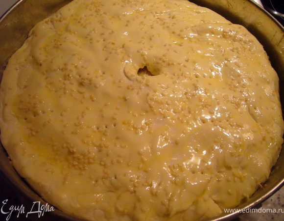 Последним получается слой курицы, его опять же сбрызгиваем топлёным маслом и накрываем раскатанным в круг слоёным тестом, смазанным желтком по краю. И тут могут быть 2 варианта. Если бортики вышли высокие, то защипываем их с верхним слоем теста и как-бы закатываем чуть к центру. Или если бортики получились не очень высокие (маловато теста взяла на нижний слой), то верхний слой подворачиваем наружу, он у нас  накрывает "бортик" нижнего слоя. За счёт того, что стенки держит разъёмная форма, тесто прилипнет и пирог впоследствии распадаться не будет. В центре делаем отверстие, чтобы выходил пар, я ещё "для верности" наколола тесто вилкой в нескольких местах. Смазываем верх пирога желтком, взбитым с солью, посыпаем кунжутом и отправляем в разогретую до 200 гр. духовку на 30 мин.