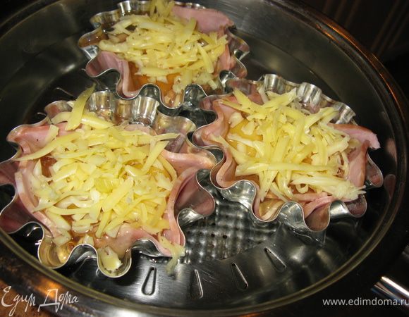 Формочки поставьте на сковороду, влейте в нее воду на 1,5-2 см. Накройте крышкой и варите 5-6 мин.