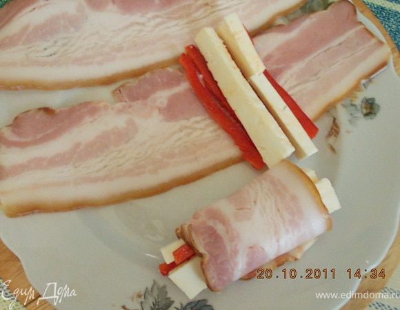 на тонкий пласт бекона уложить по два брусочка брынзы и перца,для любителей-посыпать бекон мускатным орехом,свернуть в рулетик