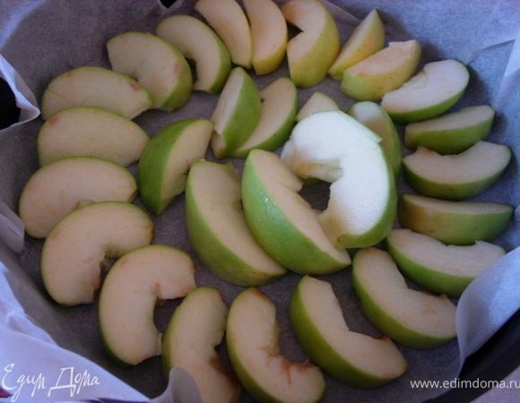 Противень застилаем пергаментом (можно чуть смазать растительным маслом) и нарезаем яблоки. Выливаем ни них тесто. 
*лучше выливать тесто на середину яблок, далее оно само растечется равномерно к краям*