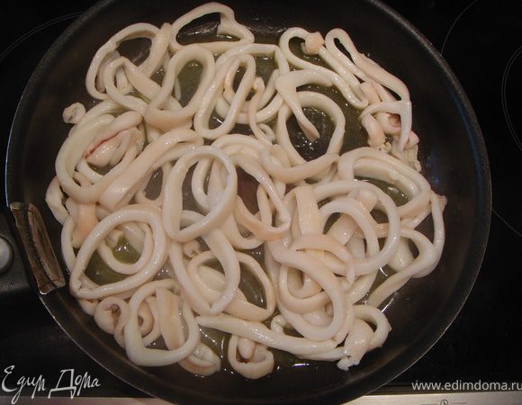 Разогреть небольшое количество оливкового масла на сковороде и  на сильном огне обжарить кольца кальмаров ОДНУ минуту. Снять с огня и сбрызнуть соевым соусом. Закрыть сковородку крышкой и оставить на 5 минут.