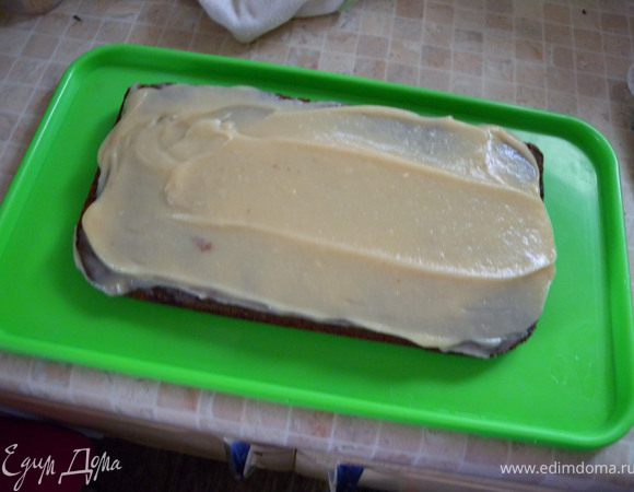 7. Варим крем. Вскипятить 400 мл молока. Крахмал развести в 100 мл холодного молока. К горячему добавить ванилин и сахар. Поставить на огонь. Помешивая влить холодное молоко с крахмалом в горячее. Прокипятить постоянно помешивая около 2-х минут. Добавить вареную сгущенку, взбить.  Промазываем теплым кремом. 