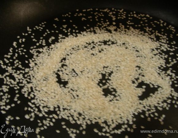 Кунжут обжарьте на сухой сковороде 3 минуты до коричневатого цвета и переложите его на тарелку.