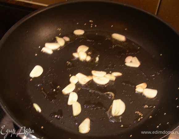 В той же сковороде обжарьте чеснок, нарезанный тонкими пластинами, на оливковом или кунжутном масле, чтобы он стал хрустящим (2–3 минуты). Выньте его с помощью шумовки.