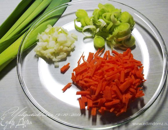 Оставшиеся 3 листа капусты нашинковать. Лук-порей нарезать кольцами, 1 морковь нашинковать соломкой, 1 луковицу мелко нарезать. Грибы разморозить и нарезать на кусочки.