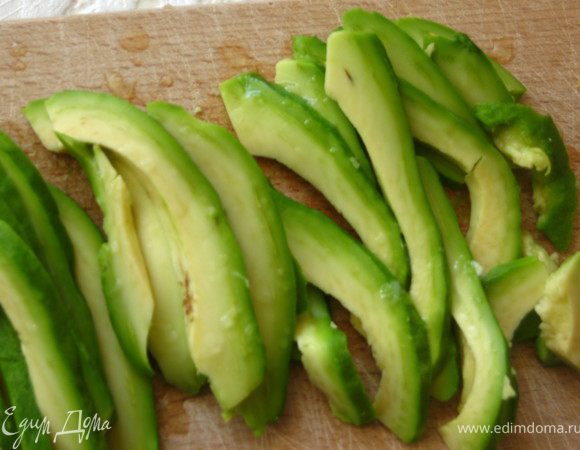 Авокадо очистить, нарезать тонкими пластинкам, сбрызнуть лимонным соком.