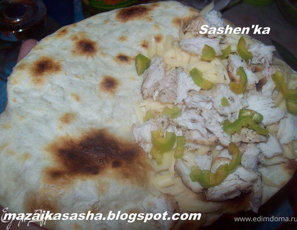 Сыр натереть на крупной терке, курицу измельчить, мелко порезать перчик чили (с чили не перестарайтесь) и выложить все на один край лепешки