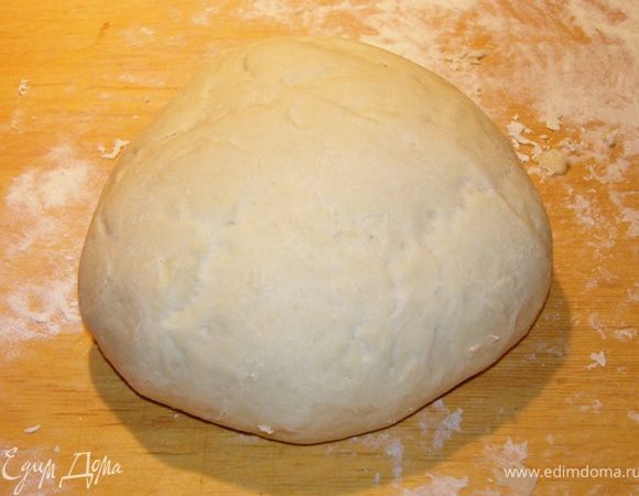 Дрожжи смешаем с чайной ложкой сахара и столовой ложкой воды, дадим постоять до появления пены. На доску насыпем муку горкой, сделаем углубление, выльем дрожжи, оливковое масло и воду, аккуратно размешивая. Замесим тесто. Вымешивать нужно минут 5-10. Накроем полотенцем и дадим полежать около часа до увеличения объема вдвое.