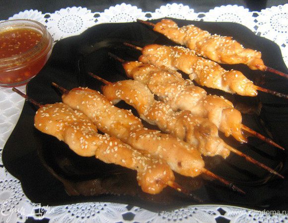 Куриное филе нарезать по диагонали тонкими длинными полосками. На низать на деревянные шампуры и уложить в широкую миску. 
Мармелад мелко порезать и растопить его на водяной бане , добавить в него лимонный сок, соевый соус, масло,измельчённый чеснок, соль, перец. Полученным маринадом залить шашлыки. Закрыть пленкой и оставить на 2 ч.(я поставила мариновать шашлычки в холодильник и у меня маринад застыл,но это не страшно,он всё равно потом в духовке разогреется)
Уложить шашлыки на смазанный маслом противень(я уложила на фольгу,смазанную маслом) и запекать в разогретой до 200С духовке в режиме "гриль" переодически поливая шашлычки маринадом,15 минут,через 15 минут шашлычки посыпать кунжутными семечками и оставить в духовке ещё на 5 минут.Оставшийся маринад вылить в подходящую посуду и подать к шашлычку.Ну очень вкусно!