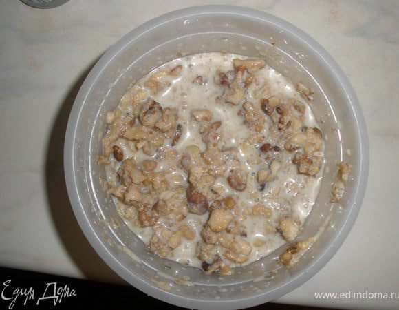 Пока корж горячий, выкладываем на него орехи смешанные со сгущенкой и размазываем. Сразу скручиваем в рулет. 