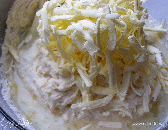 В подошедшую опару вылить оставшееся молоко, смешанное с 3-мя чайными ложками сахара, щепоткой соли и яйцом, выложить натертый маргарин или сливочное масло, высыпать оставшуюся муку. 