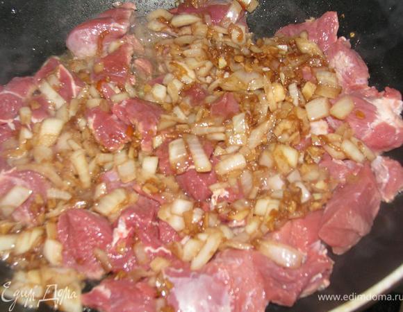 Через минуту добавить мясо, порезанное небольшими кусочками. Обжарить пару минут на сильном огне. 
