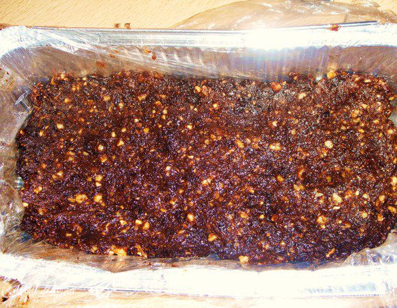 Чернослив измельчить в блендере с орехами и какао в грубое пюре. овсяные хлопья слегка обжарить, добавить в черносливное пюре. выложить массу в форму(застеленную пищевой пленкой), разровнять и убрать в холодильник. 

