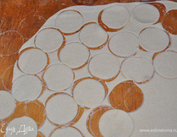 тесто разделить на 4 части и каждую раскатать в тонкий лист.Стаканчиком вырезаем кружочки для пельмешек.