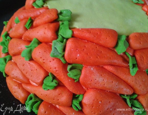Лепим морковки. Их можно сделать заранее. Так как морковки в 3D, то они могут потянуть много мастики и занять много места. Их можно сделать пустотелыми половинками. Я делала из минимума мастики. Внутрь - миндаль. У него такая подходящая форма. Зеленые хвостики и черточки - зубочисткойПриклеиваем морковки по кругу, начиная внизу. 