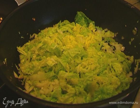 Разогреть в тяжелой сковороде 1 ст. ложку оливкового масла и сливочное масло, добавить капусту и лук, перемешать, накрыть крышкой, уменьшить огонь и обжаривать пару минут.