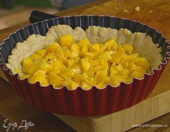 Вынуть пирог из духовки, выложить на него кусочки манго.
