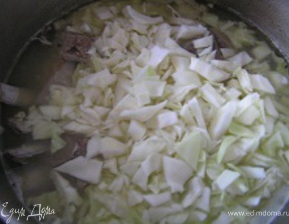 Тем временем нашинковать капусту, добавить в кастрюлю. Варить 10-15 минут.