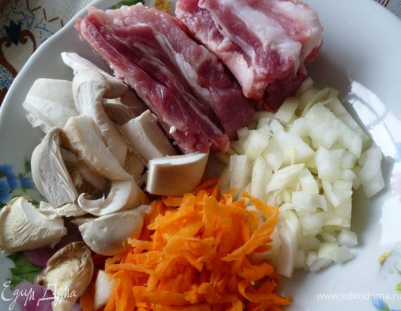 Подготовим все продукты:ребрышки нарежем на порции,морковь почистим и натрем на крупной терке,лук нарежем кубиком,грибы нарезать не очень мелко.