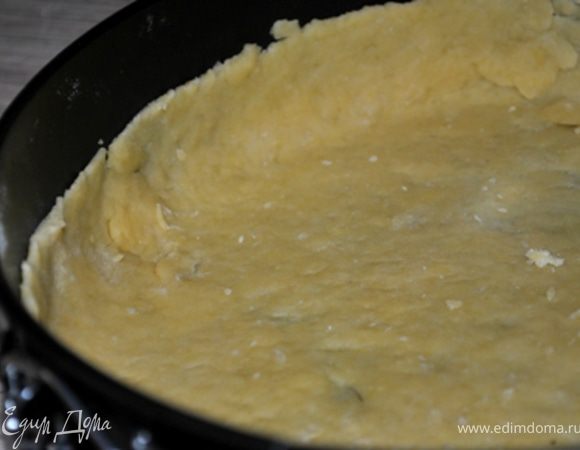 Муку смешать с солью и разрыхлителем. Добавить кубики масла и растереть руками в крошку. Добавить желток, воду и замесить крутое тесто. Убрать холодильник на 20 минут.
Вынуть тесто, тонко раскатать, уложить на дно формы (22см в диаметре), сделать бортики. Поставить в холодильник на 15 минут.