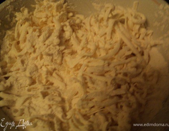 Муку смешать с разрыхлителем теста, натереть на терке охлажденный маргарин.
