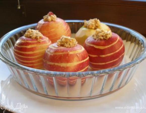 Разложить начинку по яблокам. Яблоки выложить в форму. В форму налить 1 стакан воды. Закрыть форму сверху фольгой, хорошо закрепив по краях. Выпекать в духовке при 180С около 40 минут. Если яблоки вдруг пропеклись недостаточно (это будет зависеть от сорта), снимите фольгу и верните яблоки в духовку еще на некоторое время. 