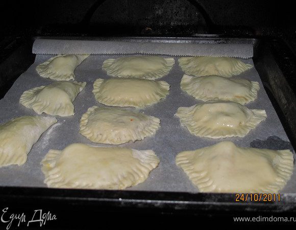 На противень постелить бумагу и увлажнить. Я кисточкой помазала водой лист. Выложить на него наши пирожки, их будет примерно 12  шт. Обмазать пирожки взбитым яйцом и запекать в духовке 20 минут. Они должны зазолотиться. 