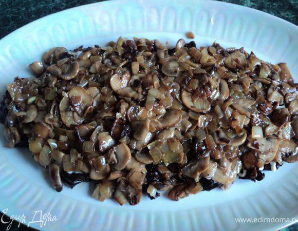 Сверху на чернослив выложите охлажденные жареные грибы, смажьте майонезом.