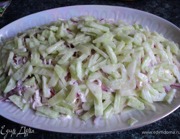 Огурцы очистите от кожицы, нарежьте брусочками и выложите на слой куриного филе с луком, сверху — майонез.