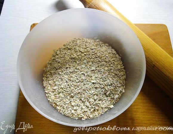 Смесь хлопьев необходимо измельчить, но не в муку, а чтобы сами хлопья чувствовались. Можно сделать это с помощью кофемолки, но я предпочла сделать это вручную: в полиэтиленовый пакет насыпать хлопья, завязать и сверху пройтись скалкой несколько раз до нужного состояния. 