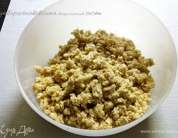 Всыпать в миску измельченные хлопья, муку, сахар и ванилин. Добавить туда нарубленное холодное сливочное масло. Получившую смесь перетереть руками в крошку.