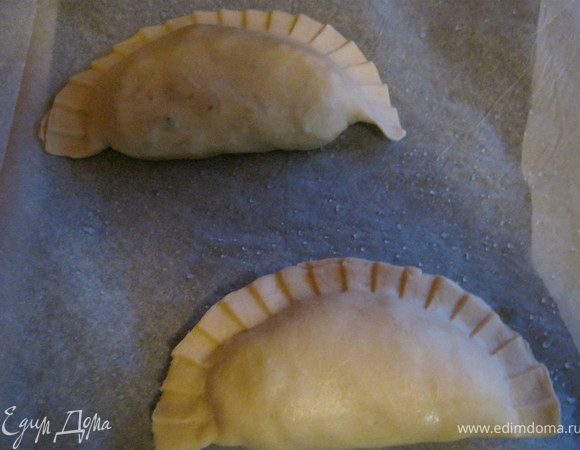 На выстланный бумагой противень уложить пирожки.(Предварительно взбрызнуть бумагу холодной водой). Смазать пирожки сверху яйцом.Выпекать до готовности.